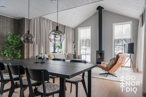 a living room with a dining room table and chairs at The Black Bear Lodge in Tällberg