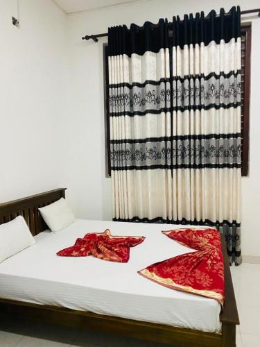 a bed with two red sarees sitting on it at Royal place in Mahiyangana