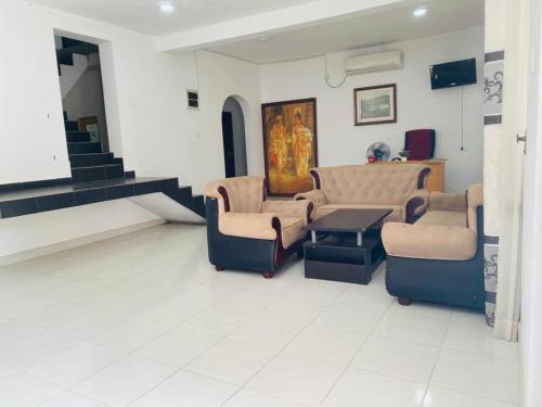 a waiting room with chairs and a table and stairs at Royal place in Mahiyangana