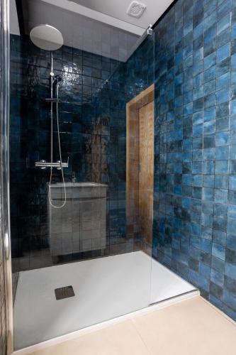 a bathroom with a shower with blue tiles at Sleep in Centre - Old Town in Aveiro