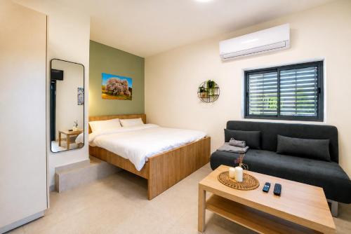 a small bedroom with a bed and a couch at בהט בגולן - מתחם נופש עם 2 דירות אירוח ברמת הגולן in Ein Zivan