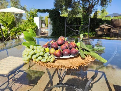 a plate of fruit on a table next to a pool at Casas Rurales Los Montes in La Corte