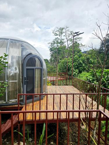 a dome house with a deck and a fence at SKYLINE vangvieng Resort in Vang Vieng