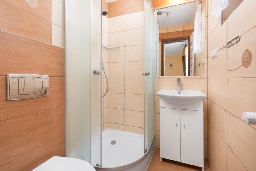 a bathroom with a shower and a toilet and a sink at Willa Czaruś in Władysławowo