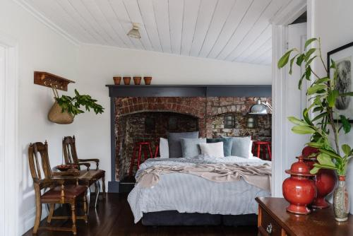 a bedroom with a bed and a brick wall at Piccadilly House Daylesford in Daylesford