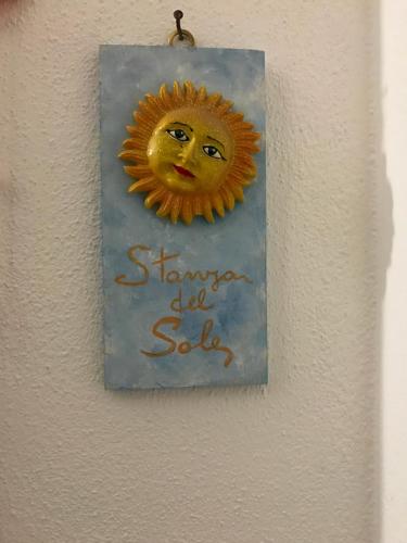 a picture of a sun sign hanging on a wall at B&B Magna Grecia in Crotone