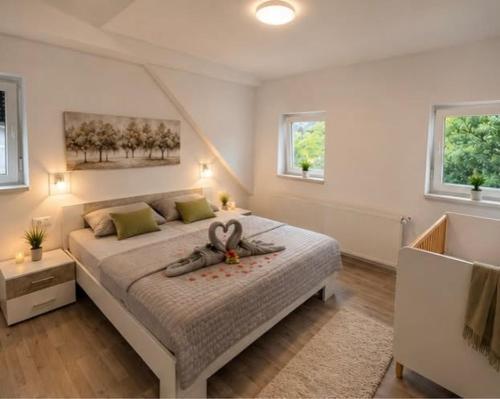 a bedroom with a large bed with two swans on it at Apartmani LU&LO in Delnice