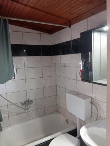 a bathroom with a tub and a toilet and a sink at Ελένη in Iraklitsa