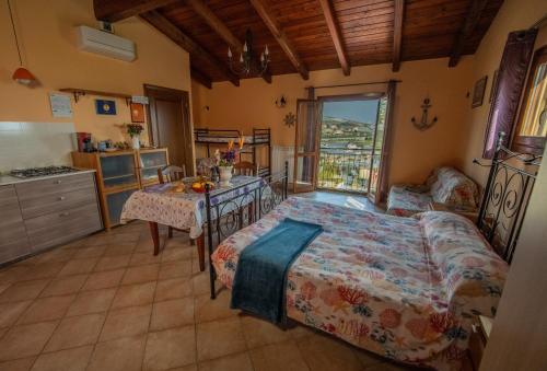 a bedroom with a bed and a table and a kitchen at Strada Casai 19 - Appartamento turistico in villa con giardino e posto auto in Riva Ligure