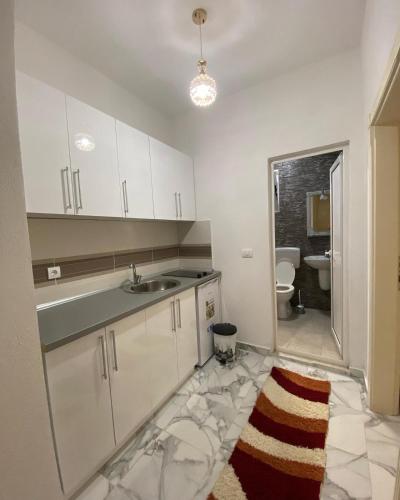 a white kitchen with a sink and a toilet at Maxhuri Apartments in Ulcinj