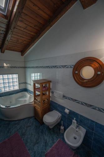 a bathroom with a tub and a toilet and a sink at Strada Casai 19 - Appartamento turistico in villa con giardino e posto auto in Riva Ligure