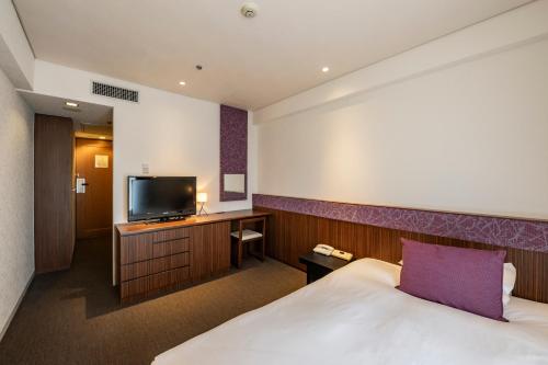 a hotel room with a bed and a flat screen tv at Kyoto Tokyu Hotel in Kyoto