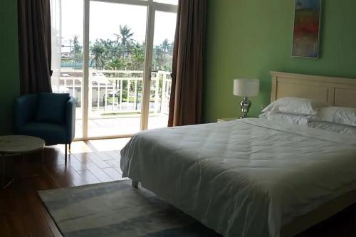 a bedroom with a bed and a chair and a window at Tinian diamond hotel in Tinian International Airport