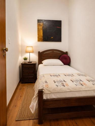 a bedroom with a bed and a table with a lamp at Casa do Botelho in Évora