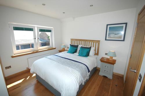 a bedroom with a bed with blue pillows and a window at The Coopers View in Cellardyke
