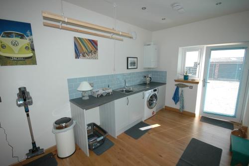 a kitchen with a sink and a washing machine at The Coopers View in Cellardyke