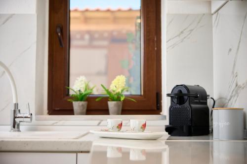 a kitchen counter with two cups and a sink at Casa di Fava in Agios Nikolaos