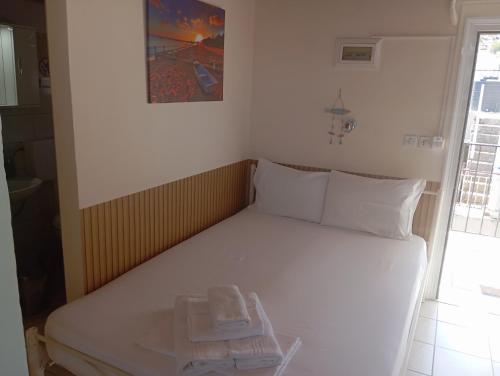 a white bed with a tray of towels on it at Ελένη in Iraklitsa