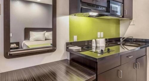 a bathroom with a sink and a bed in a room at Studio 6 Buttonwillow, CA in Bowerbank