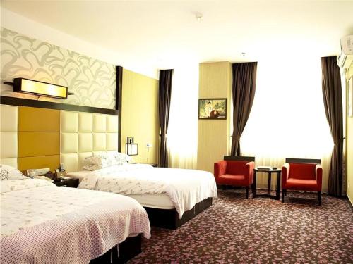 a hotel room with two beds and two chairs at Behito Hotel in Dongguan