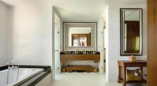 a bathroom with a tub and a sink and a mirror at Pimalai Resort & Spa in Ko Lanta