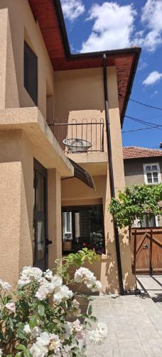 a house with a balcony and flowers in front of it at Gaga Martinovo - Mountain House - Sauna & Pool in Martinovo