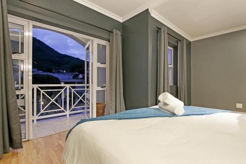 a bedroom with a bed and a large window at Bed and Breakfast Villa de la Mer in Hout Bay