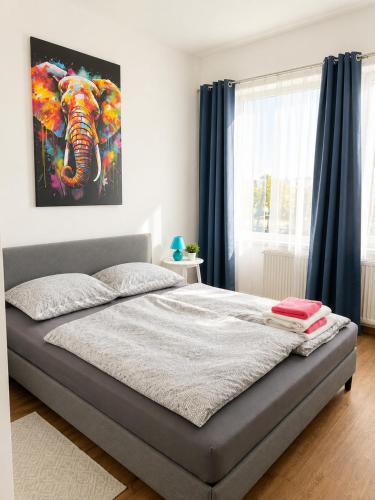 a bed in a bedroom with a painting of an elephant at LF Sports & Spa Hotel in Hannover