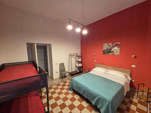 a bedroom with a bed and a red wall at B&B Enjoy Ercolano in Ercolano