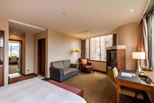 a hotel room with a bed and a chair and a television at Hotel HD Palace in Taipei
