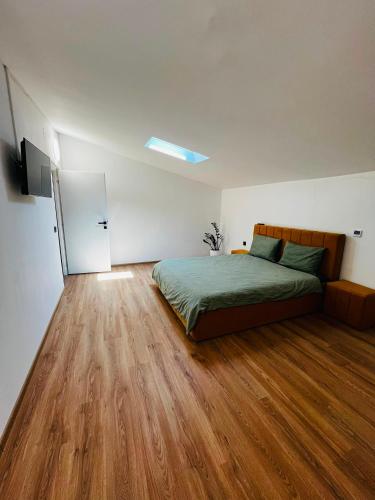 a bedroom with a bed and a hard wood floor at Antonia home 2 in Târgu-Mureş