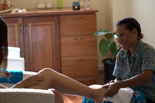a woman is sitting on a table with her leg at Rapopo Plantation Resort in Kokopo