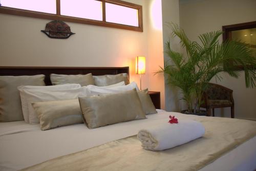 a white bed with a white pillow and a red star at Rapopo Plantation Resort in Kokopo