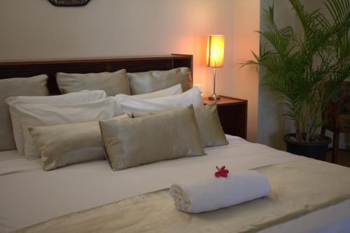 a bed with white pillows and a red star on it at Rapopo Plantation Resort in Kokopo
