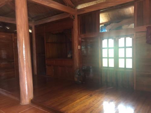 an empty room with wood floors and a window at Trà My Homestay in Nhữ Khê