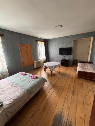 a bedroom with a bed and a table in it at LZ Green House in Telavi
