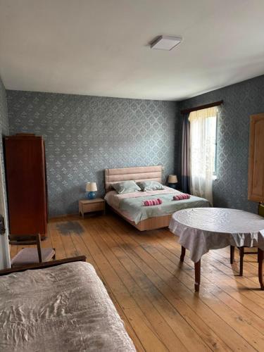 a bedroom with two beds and a wooden floor at LZ Green House in Telavi