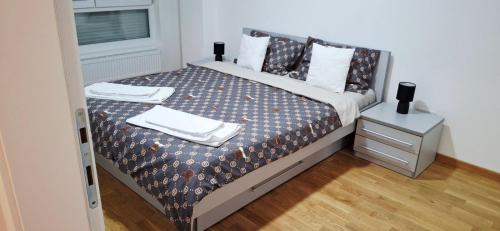 a bedroom with a bed with towels on it at Apartman Tara Jagodina, ima free parking u garazi in Jagodina