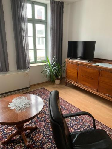 a living room with a table and a tv at Altstadt Ferienwohnung in Wismar