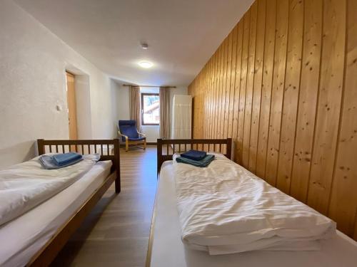 two beds in a room with wooden walls at Appartement Bergschaf in Holzgau