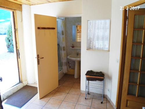 a bathroom with a yellow door and a sink at La Petite Bergerie in Drôme Provençale in Rottier