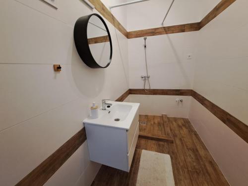a bathroom with a white sink and a mirror at Most Apartmanok in Sátoraljaújhely
