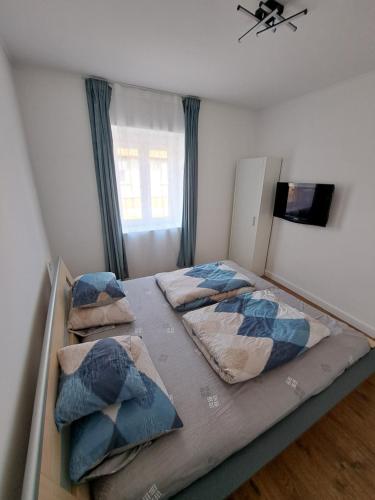 a bedroom with two beds and a window at Most Apartmanok in Sátoraljaújhely