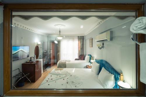 a reflection of a bedroom with a bed in a mirror at Basileus Hotel in Istanbul