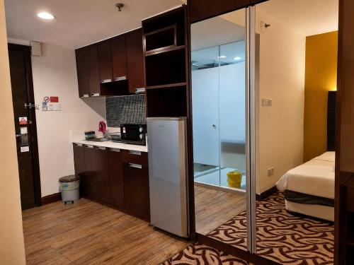 a small kitchen with a refrigerator in a room at Cozy Studio at SCSP Suites in Kota Kinabalu