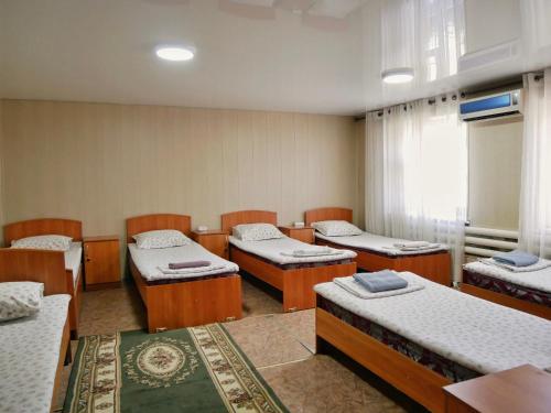 a room with four beds and a window at Sakura Guesthouse in Bishkek