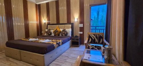 a bedroom with a bed in a room with a window at The White Yak Hotel in Leh