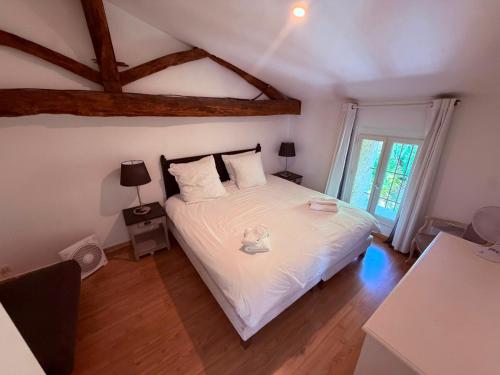 a bedroom with a large bed with white sheets at La Marcillande in Saint-Cyprien