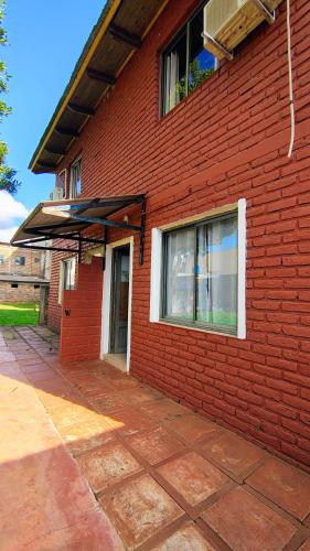 a red brick building with an umbrella on it at Departamento cercano al centro in Oberá