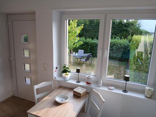 a dining room with a table and a large window at Ferien-Appartement Schröer in Nordwalde